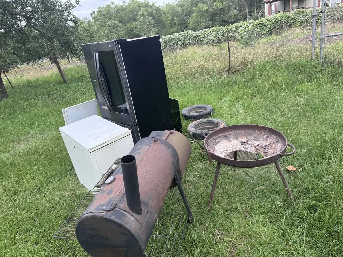Appliances and scrap staged for loading on a Brazos Valley property cleanout