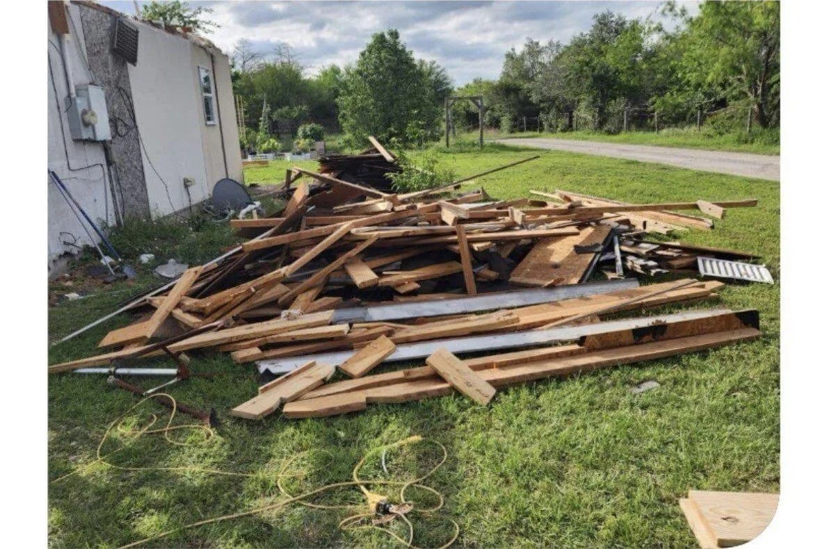 Fence and lumber demolition debris staged for ME3 Junk Solutions haul-off in the Brazos Valley