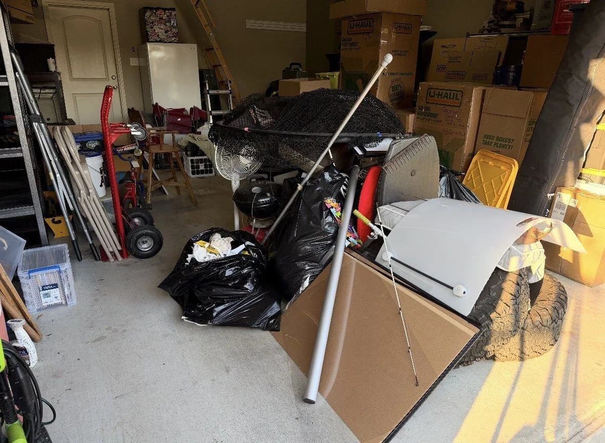 Garage packed with boxes and bulky items before an ME3 Junk Solutions cleanout