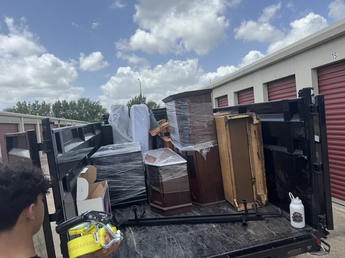ME3 Junk Solutions trailer loaded with furniture outside a Brazos Valley storage facility